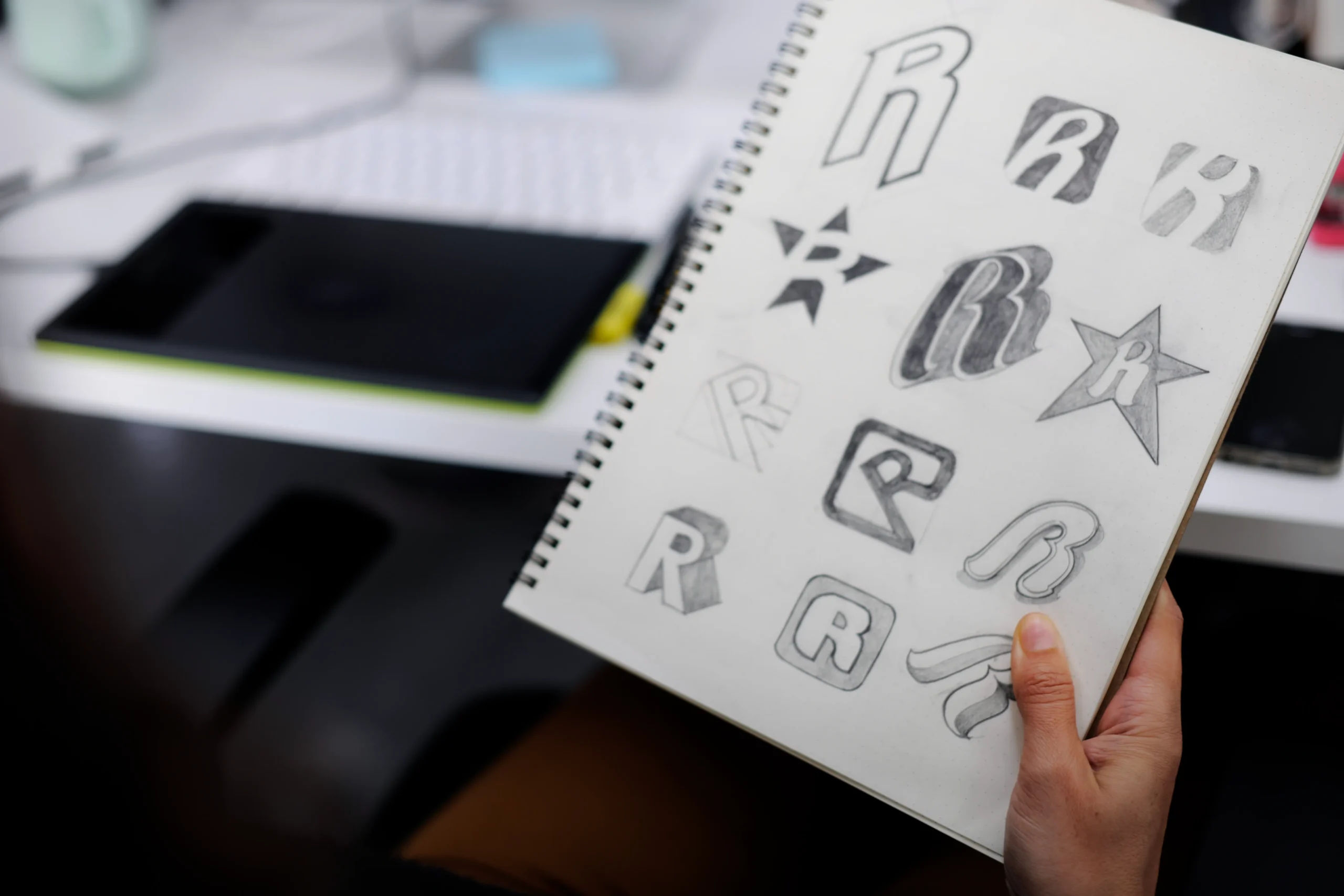 Image d'un carnet de notes avec des croquis de logo.