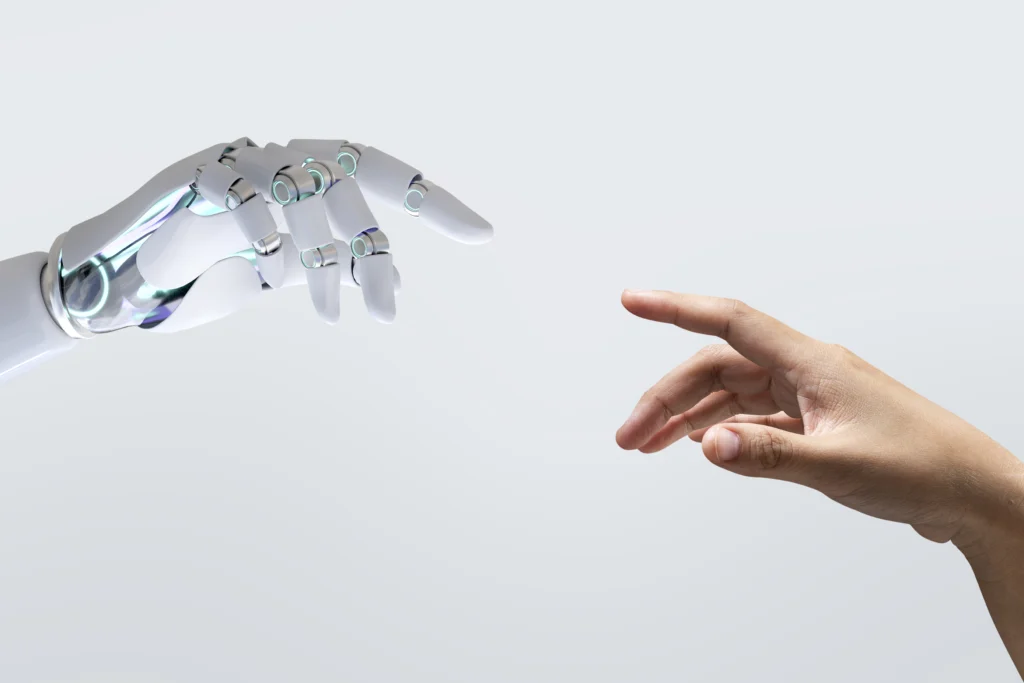 Une main humaine à droite, tendue vers une main robotique à gauche.